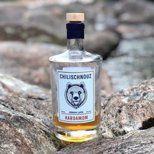 Stimmungsbild Chilischnouz Kardamom Likör – Gewürze, warmes Licht und die Flasche sinnlich inszeniert